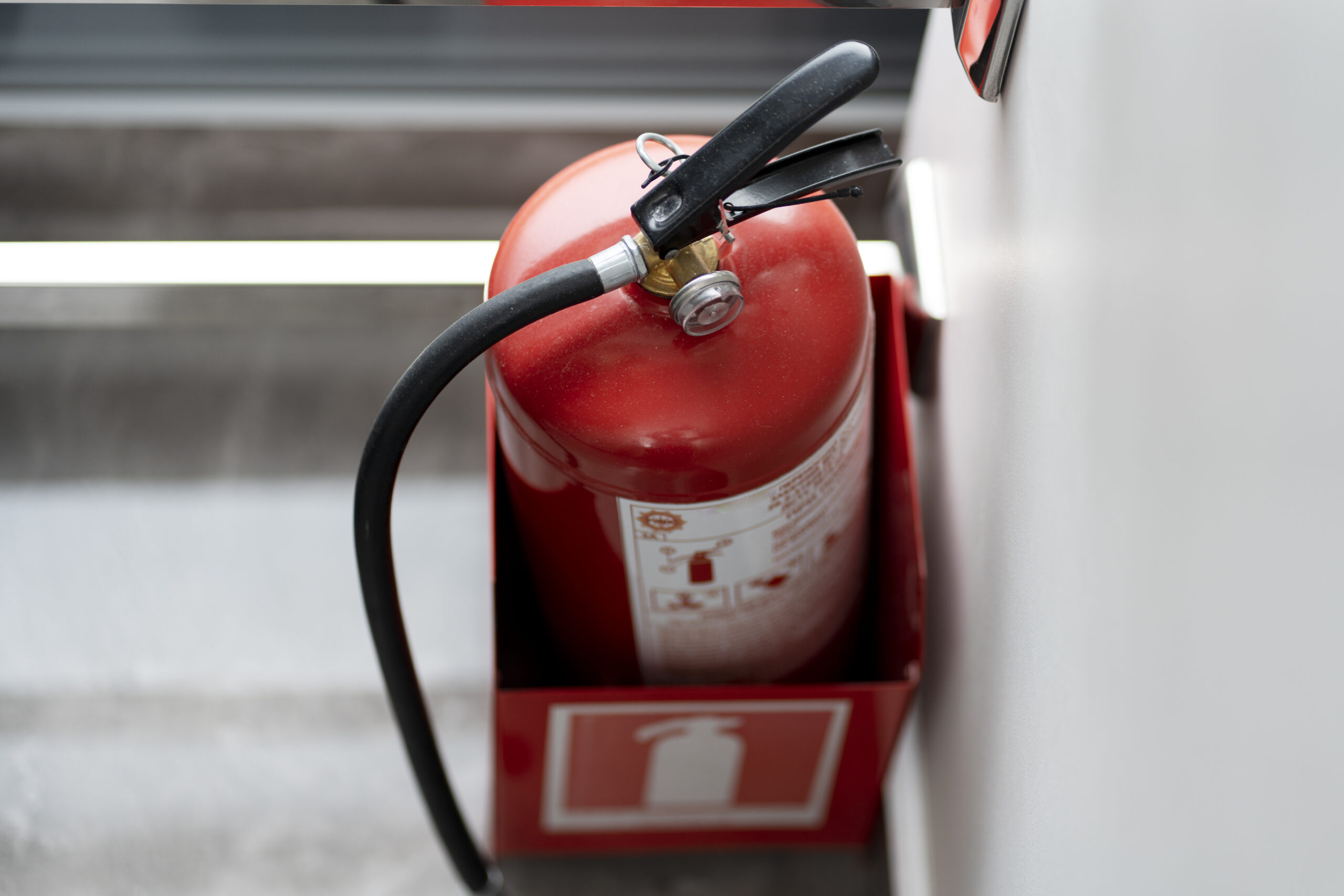 Top view, red fire extinguisher in room, copy space. Life safety, emergency, fire fighting.